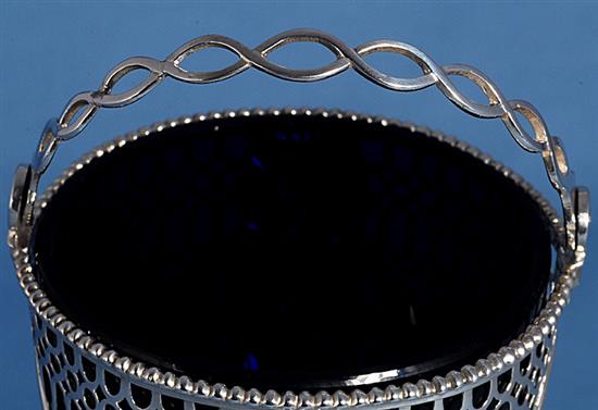 A George III silver swing handled sugar basket with blue glass liner, height to top of handle 5 ¾”/147mm Diameter 3”/79mm.